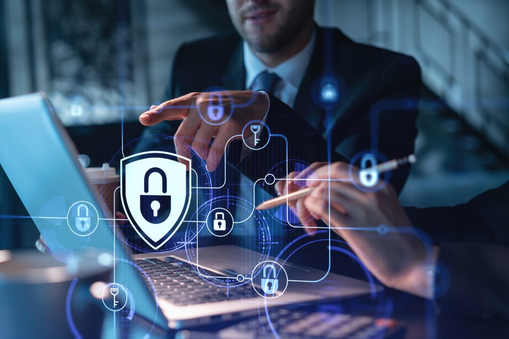 Two colleagues working together to protect clients confidential information and cyber security. IT hologram padlock icons modern office background at night time; Shutterstock ID 2013901751; purchase_order: Limited 6/4/2024; job: ; client: ; other: